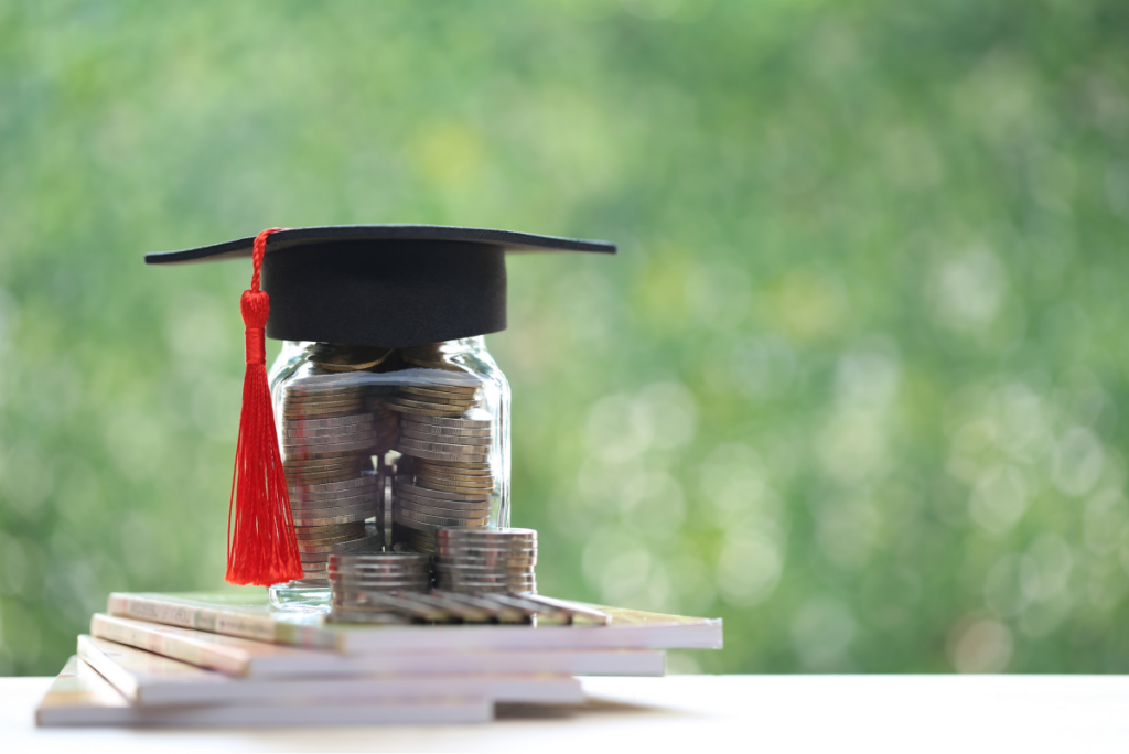 Vidro com moedas. Sobre ele está um capelo de formatura. Agronomia.