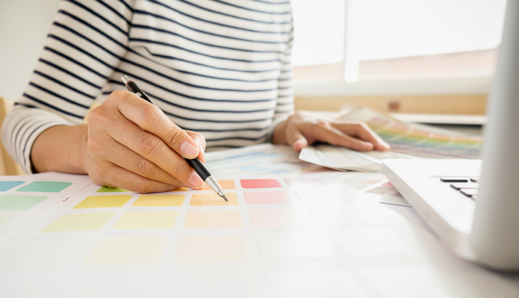 Mulher analisa paletas de cores em frente ao computador. Arquitetura.