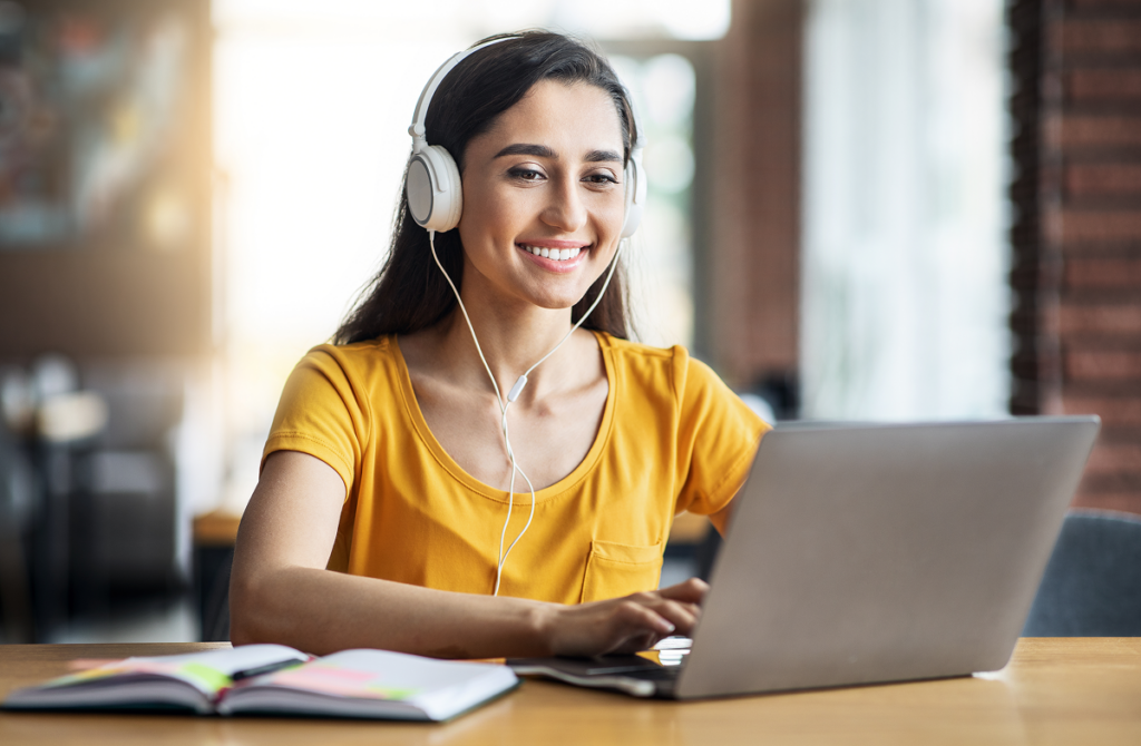 Mulher jovem estudando no computador de fones de ouvido. Ead gestão comercial.