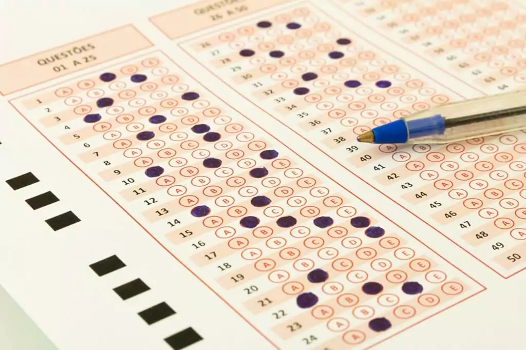 gabarito de prova preenchido e caneta azul por cima