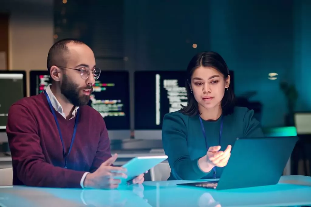 homem e mulher analisando dados em computador e tablet