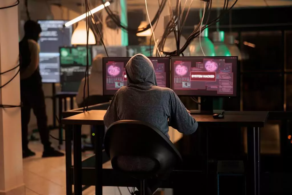 hacker em sala com computadores
