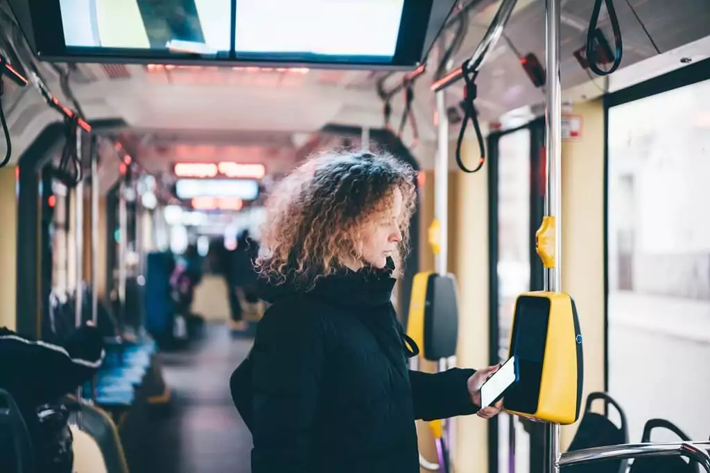 mulher em ônibus com celular