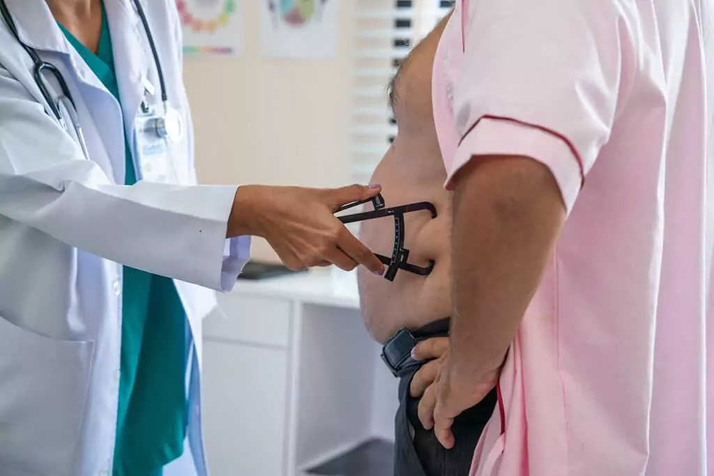 médico medindo a barriga do paciente