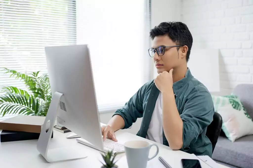rapaz pensando diante de computador
