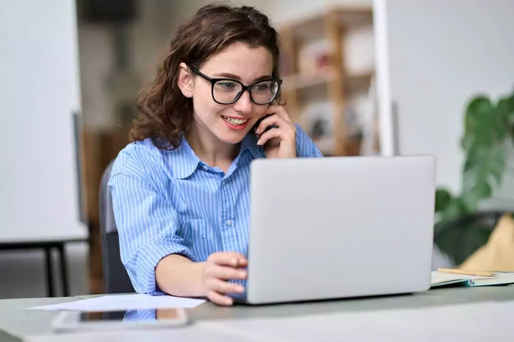 moça ao telefone olhando computador