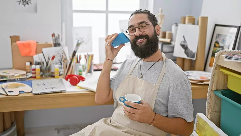 rapaz em ateliê tomando café