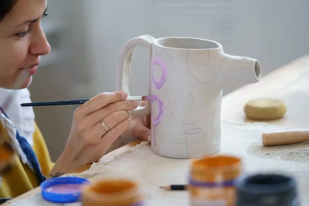 moça pintando caneca com tinta