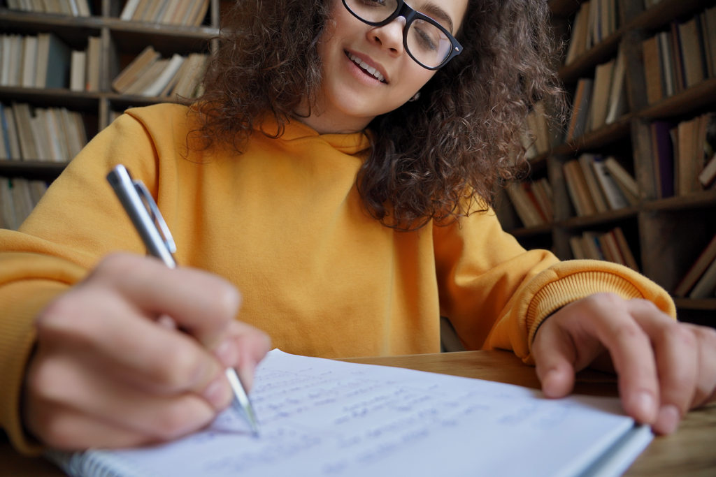 Jovem estudando em biblioteca.