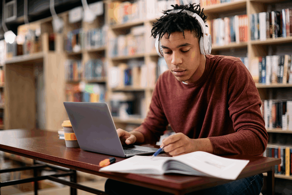 Homem jovem estudando em biblioteca. Diferença entre EAD semipresencial e presencial